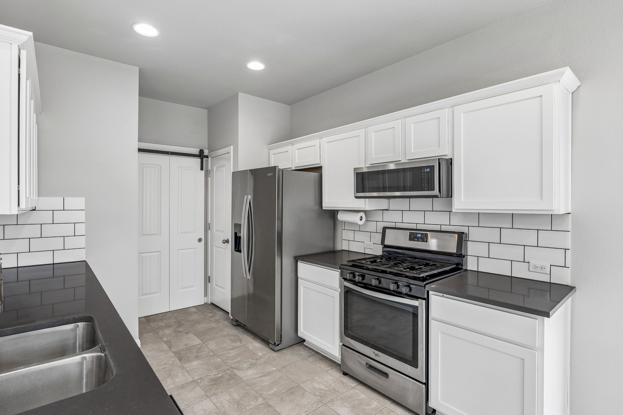 689 Nautical Loop Kyle, TX 78640 - Photo 12 of 34 Clean lines define this kitchen, showcasing a stainless-steel range and subway tile backsplash.