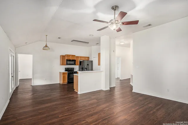 a view of a kitchen with wooden floor and a ceiling fan