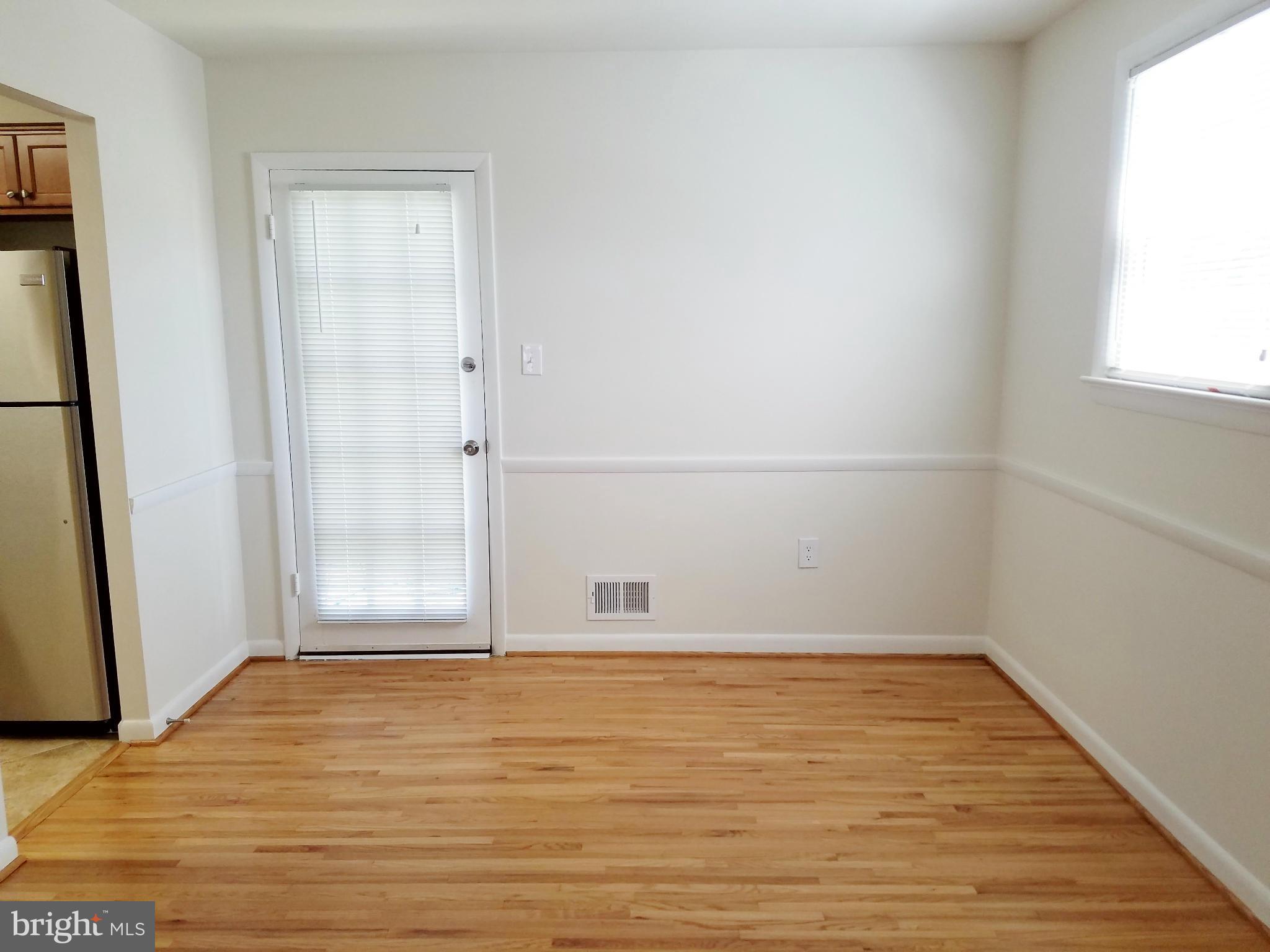 12908 Glynis Road Clinton, MD 20735 - Photo 11 of 30 a view of an empty room with wooden floor and a window