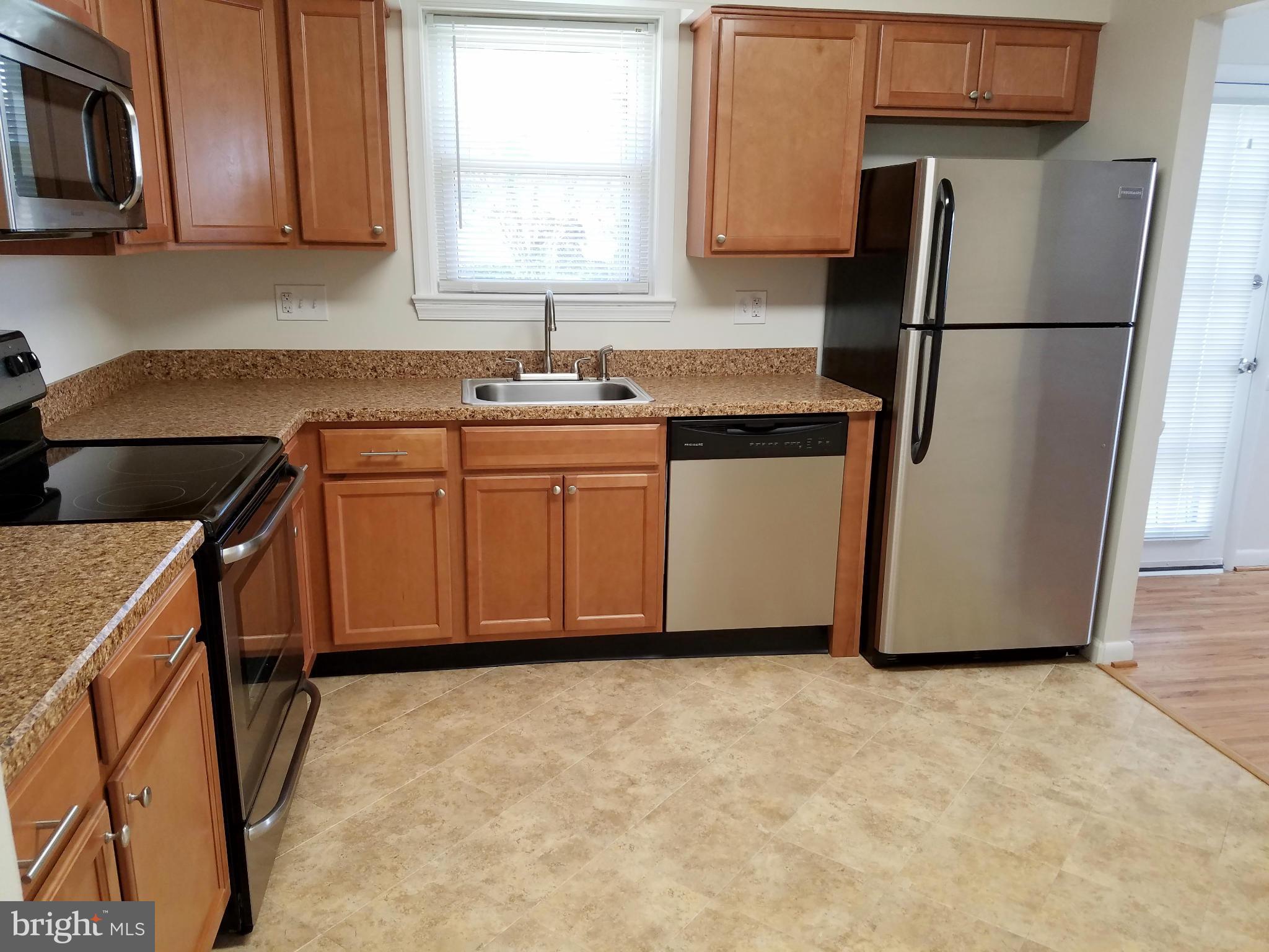 12908 Glynis Road Clinton, MD 20735 - Photo 12 of 30 a kitchen with stainless steel appliances granite countertop a refrigerator a sink a stove a microwave and island