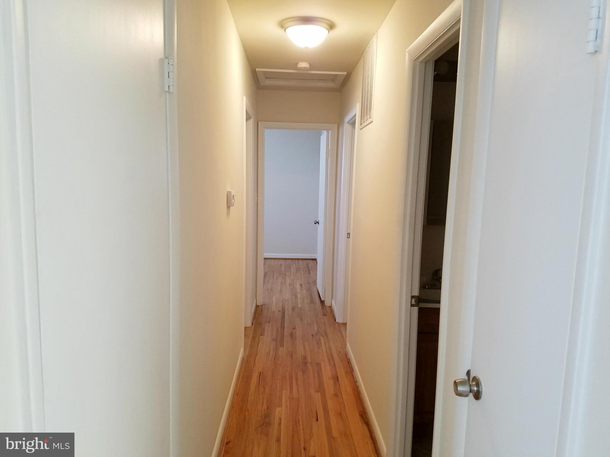 12908 Glynis Road Clinton, MD 20735 - Photo 17 of 30 a view of a hallway with wooden floor