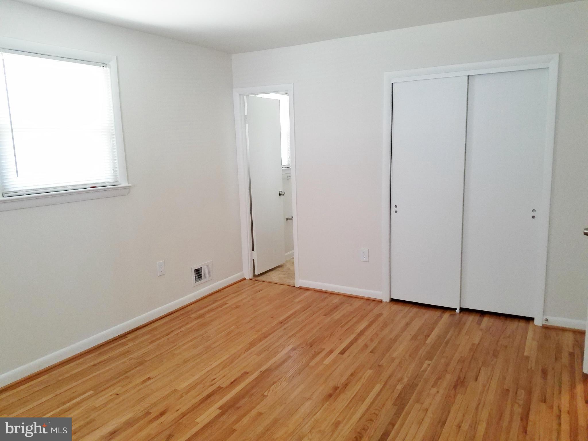 12908 Glynis Road Clinton, MD 20735 - Photo 18 of 30 a view of an empty room with wooden floor and a window