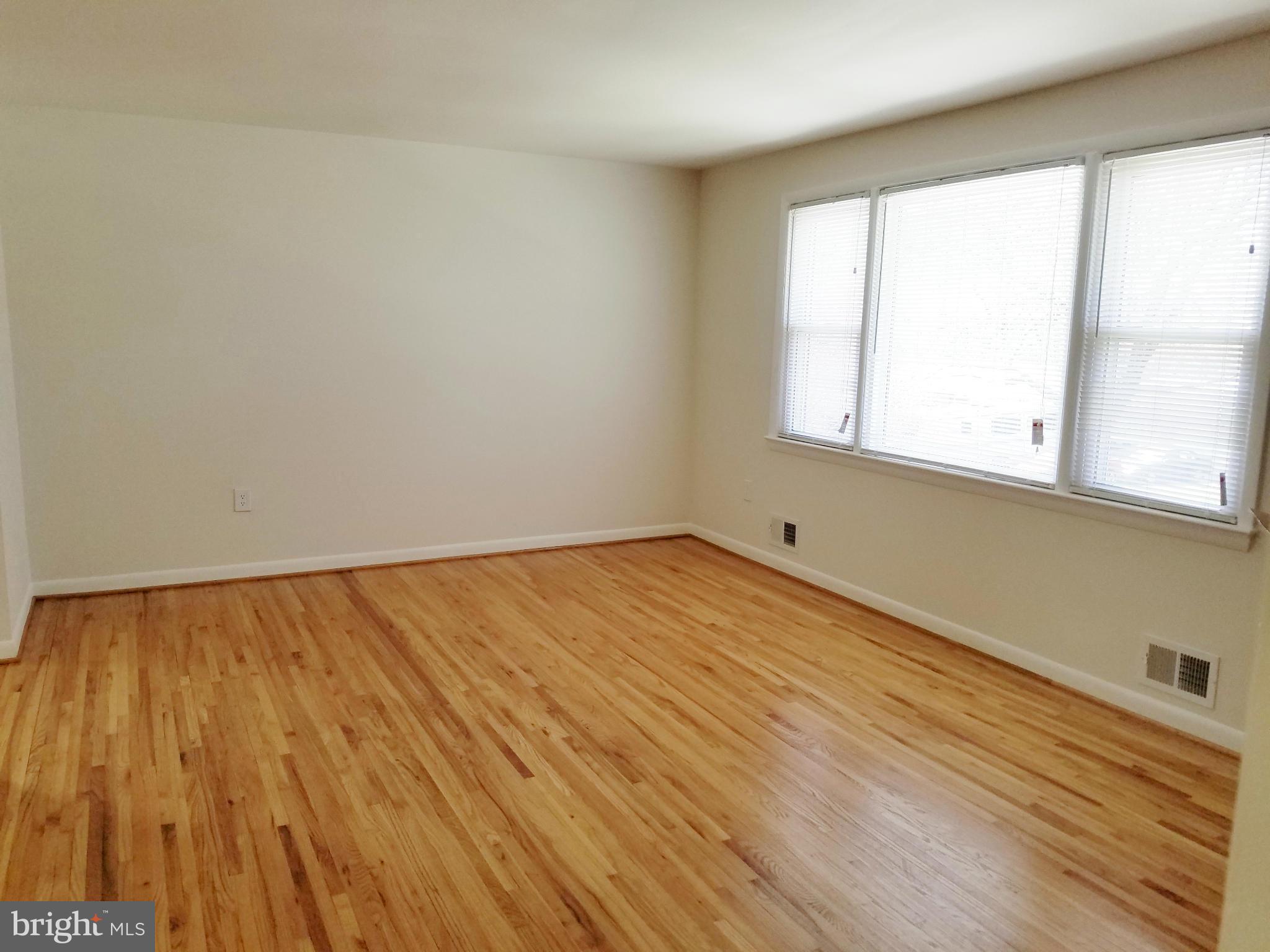 12908 Glynis Road Clinton, MD 20735 - Photo 9 of 30 an empty room with wooden floor and windows