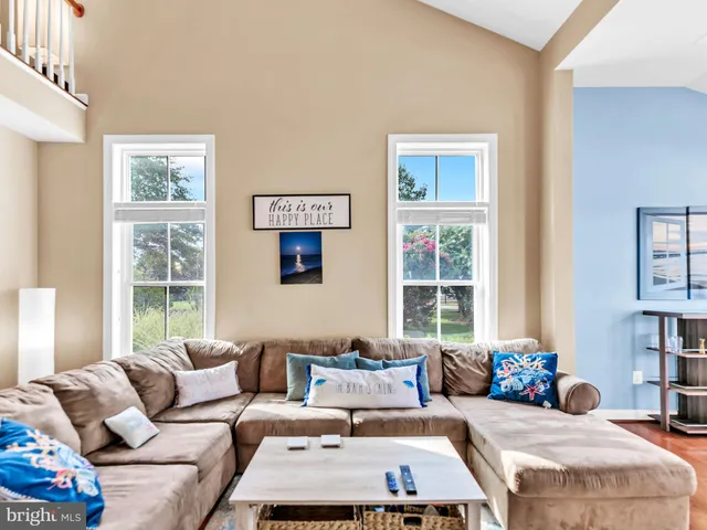 a living room with furniture wooden floor and a large window