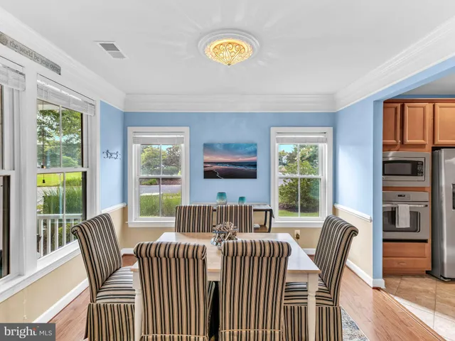 a view of a dining room with furniture a chandelier and wooden floor