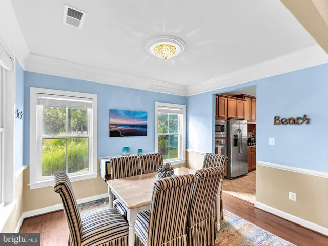 a view of a dining room with furniture a chandelier and a large window