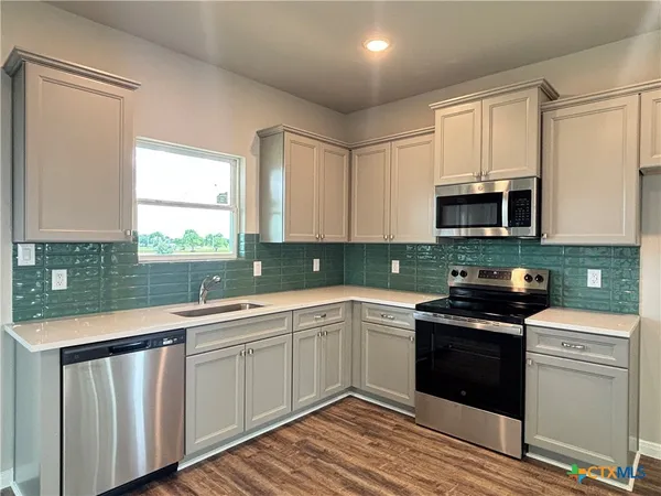 a kitchen with a sink stove top oven and cabinets