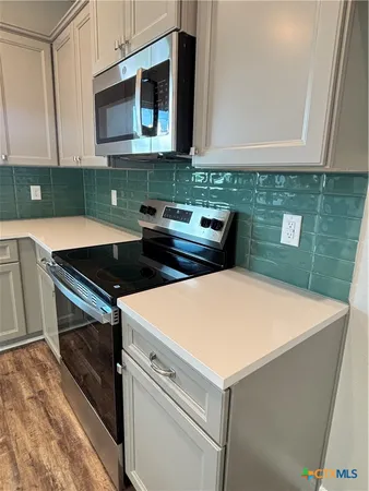 a kitchen with stainless steel appliances a stove a microwave and sink