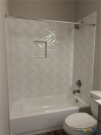a bathroom with a toilet and a shower