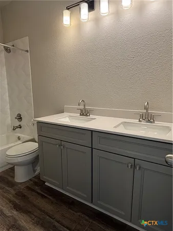 a bathroom with a double vanity sink toilet and a mirror