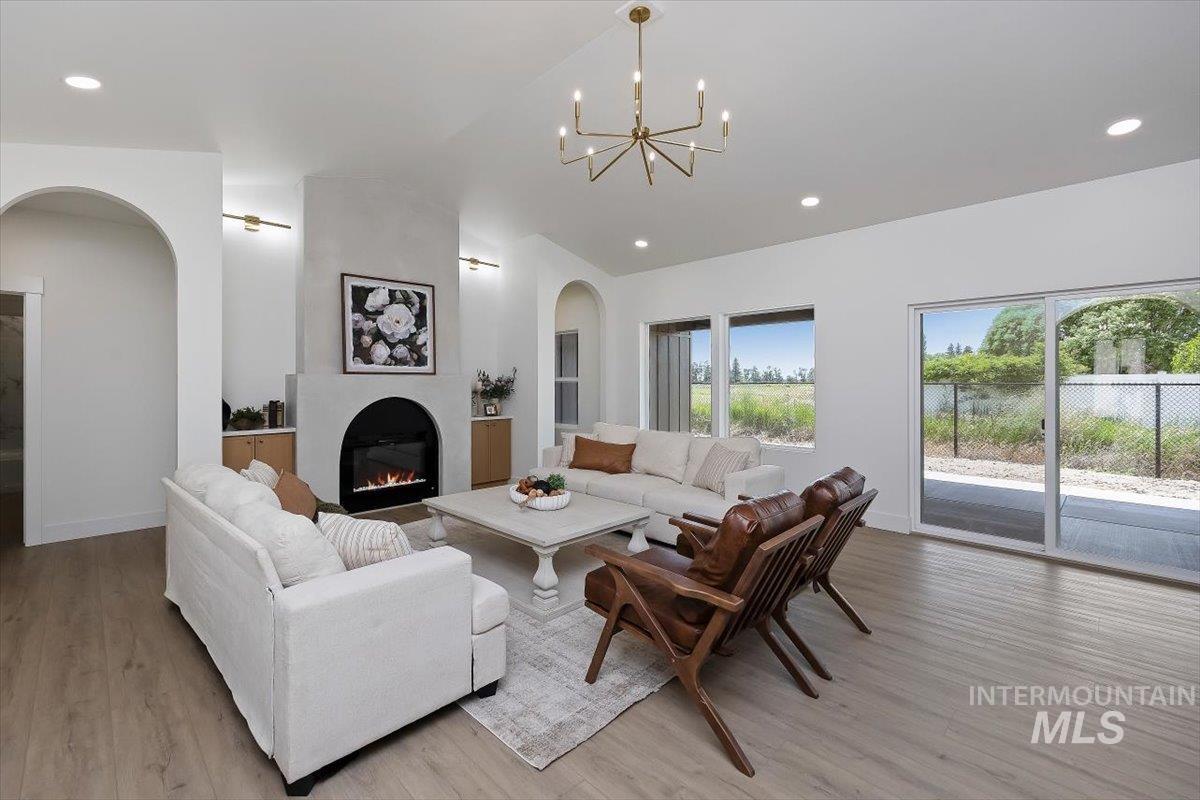 2005 Sparrow Street Rupert, ID 83350 - Photo 5 of 30 Vaulted ceilings define this living space featuring wood-finish flooring, a contemporary fireplace with a plaster surround, built-in cabinetry, and multiple windows