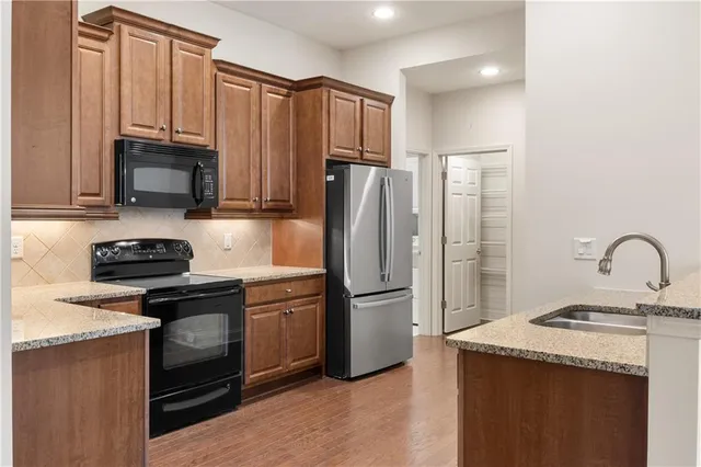 a kitchen with granite countertop a refrigerator stove and sink