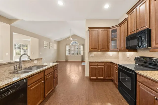 a kitchen with stainless steel appliances granite countertop a sink stove and refrigerator