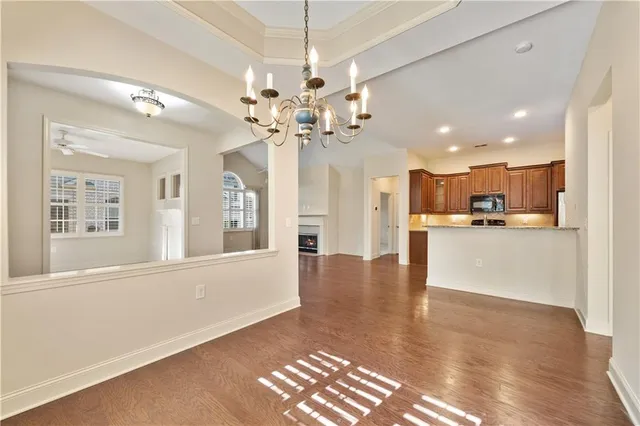 a view of an empty room with kitchen and window