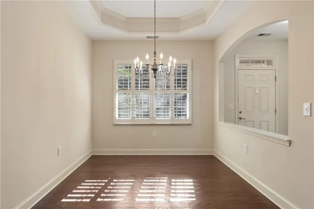 an empty room with windows and chandelier