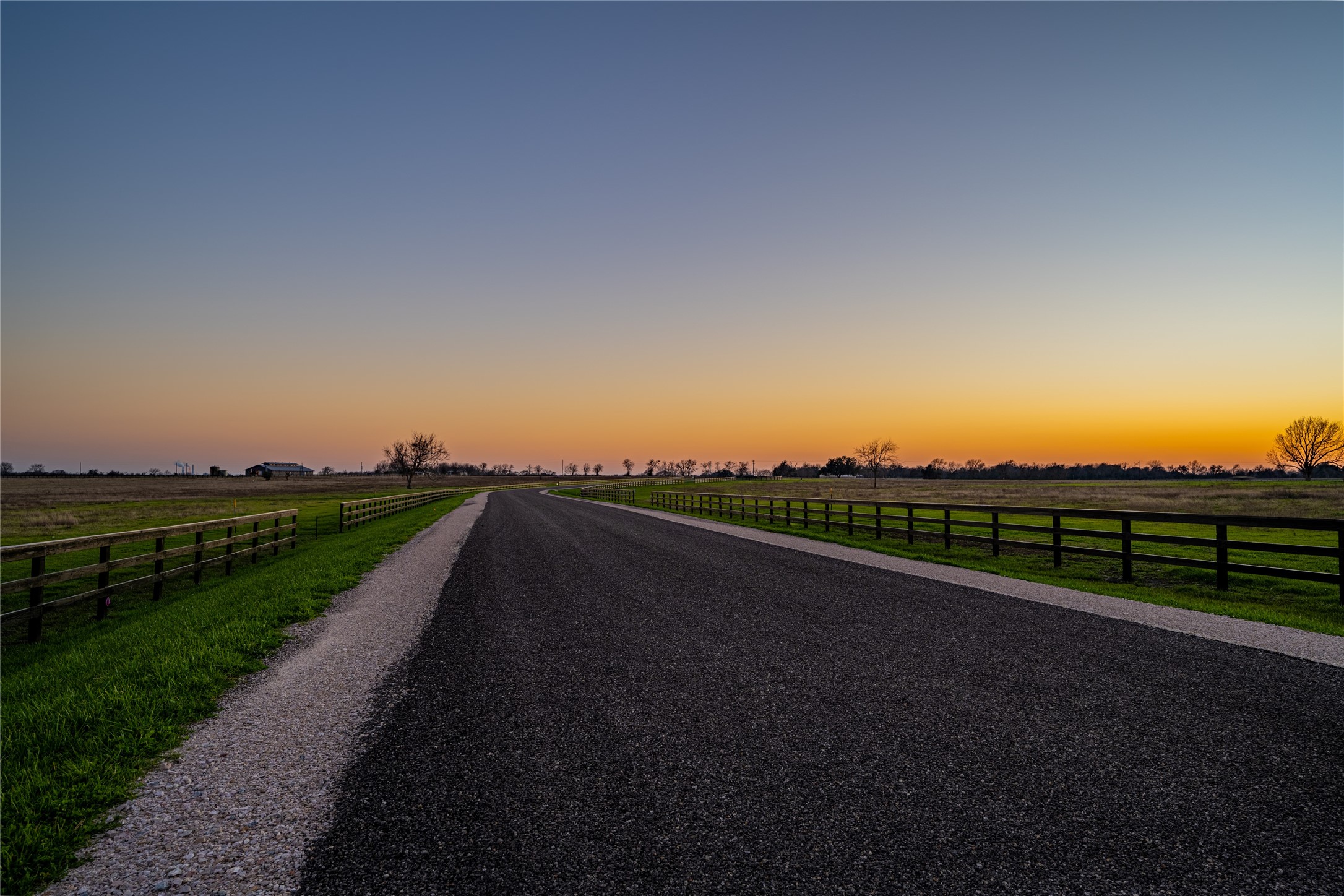 108 Hartfield Road Round Top, TX 78954 - Photo 16 of 17 a view of a street next to a lake with a big yard