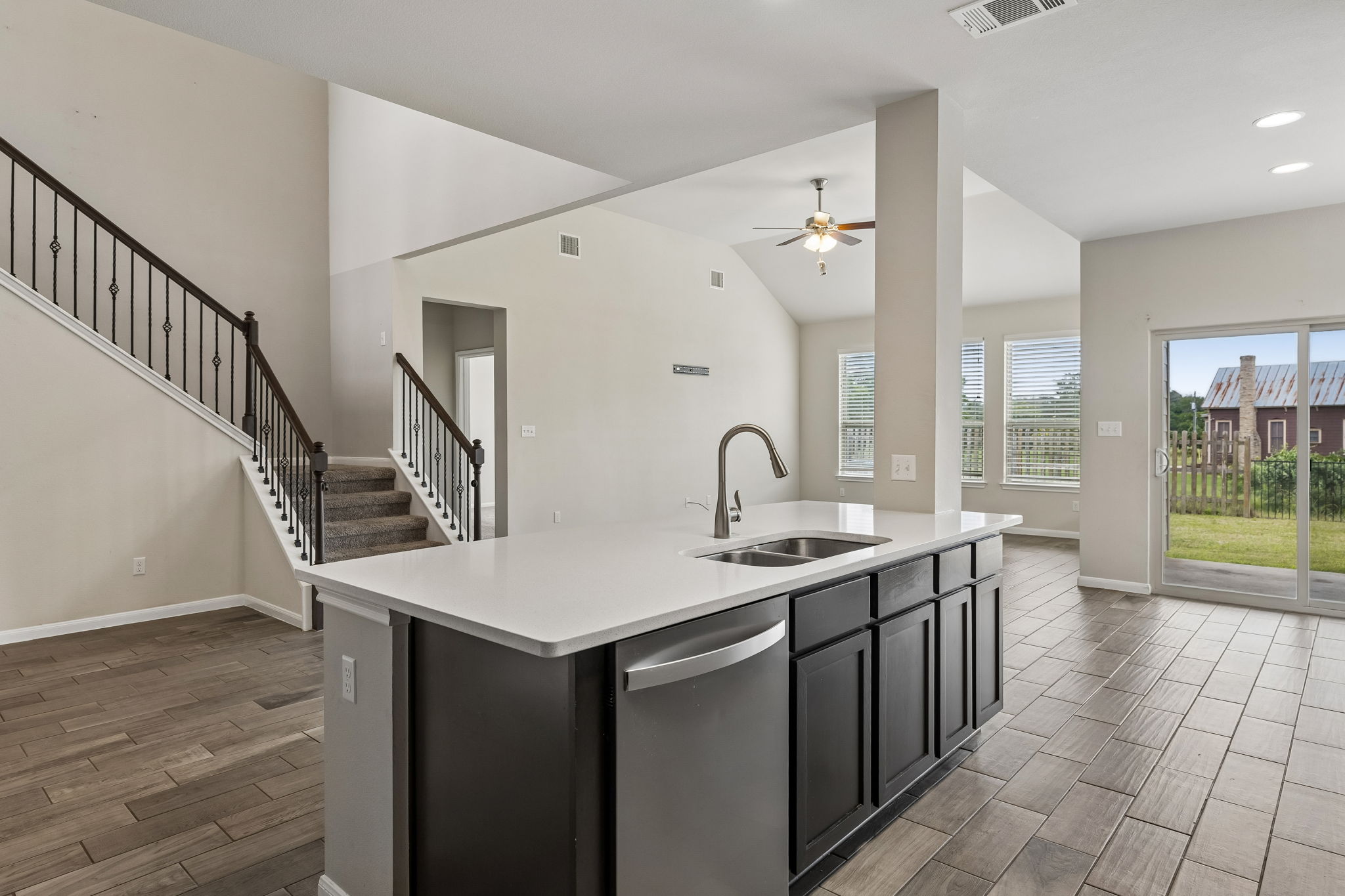 301 Rimrock Court Bastrop, TX 78602 - Photo 9 of 21 A contemporary kitchen island and sleek flooring anchor this bright, open-concept living space.
