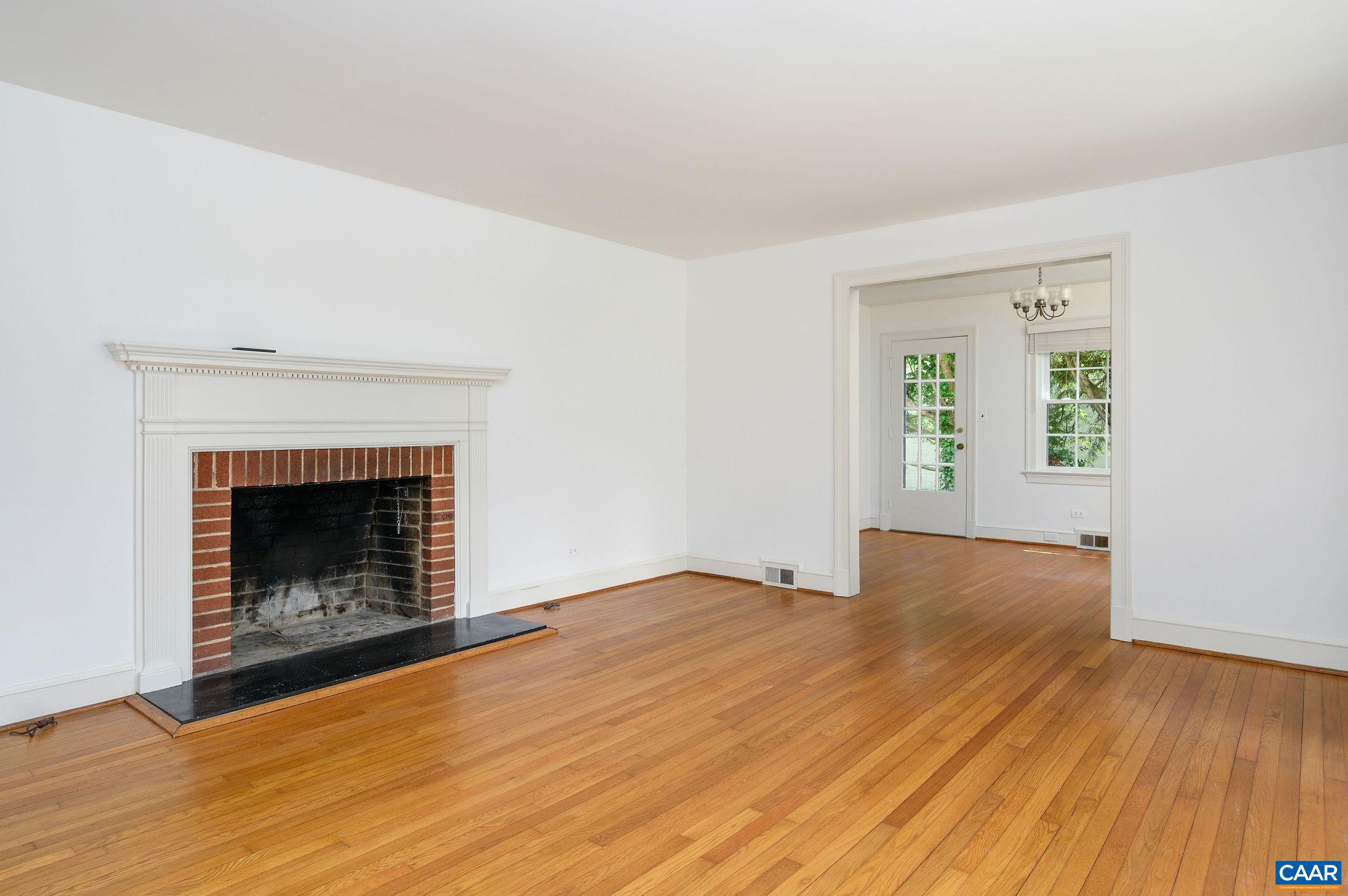 906 Old Farm Road Charlottesville, VA 22903 - Photo 6 of 46 an empty room with wooden floor fireplace and windows