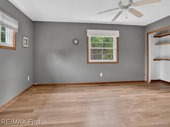 56375 Bates Road New Baltimore, MI 48051 - Photo 27 of 35 Spacious room showcasing hardwood flooring, gray walls, and abundant natural light from a large multi-pane window with wood trim