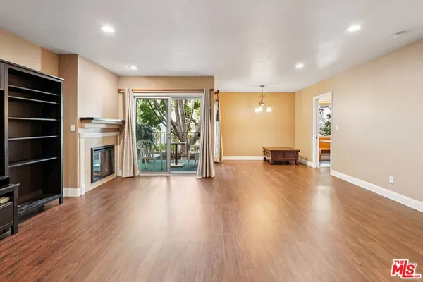 a view of a room with wooden floor fireplace and windows