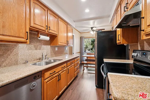 a kitchen with stainless steel appliances granite countertop a sink a stove and a refrigerator