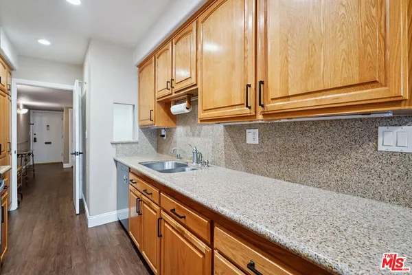 a kitchen with stainless steel appliances granite countertop a sink and dishwasher cabinets with wooden floor