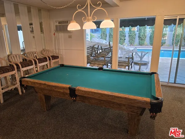 a room with pool table and windows