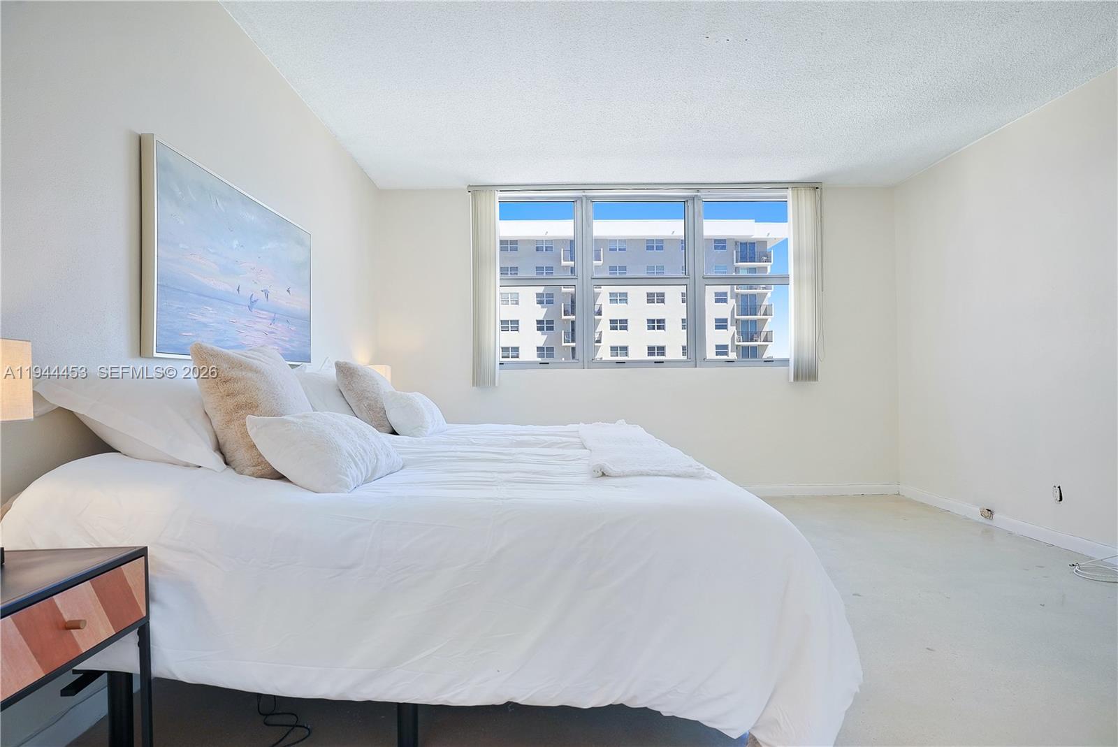 9225 Collins Avenue, Unit 705 Surfside, FL 33154 - Photo 8 of 17 a bedroom with a bed and a window