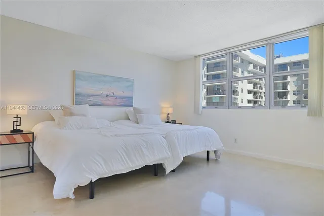 a bedroom with a bed lamp and a large mirror