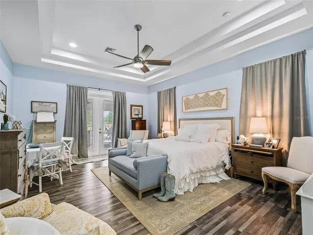 a spacious bedroom with a bed a couch and large windows