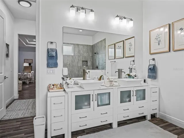 a living room with furniture a bookshelf and a flat screen tv