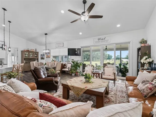 a living room with furniture kitchen view and a large window