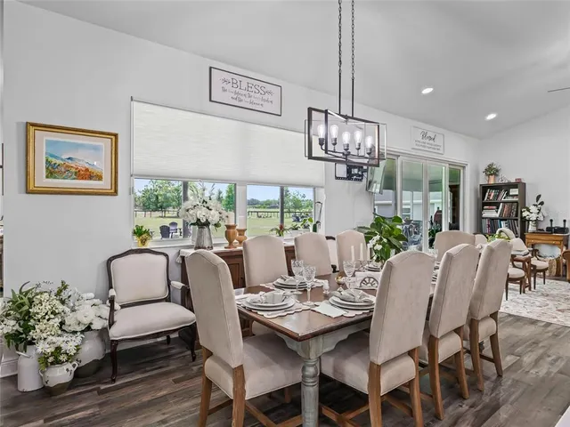 a dining room with furniture a chandelier and window