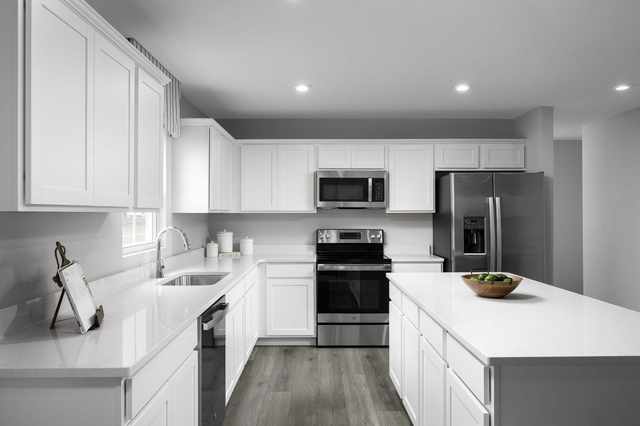 a kitchen with a sink a counter top space stainless steel appliances and cabinets