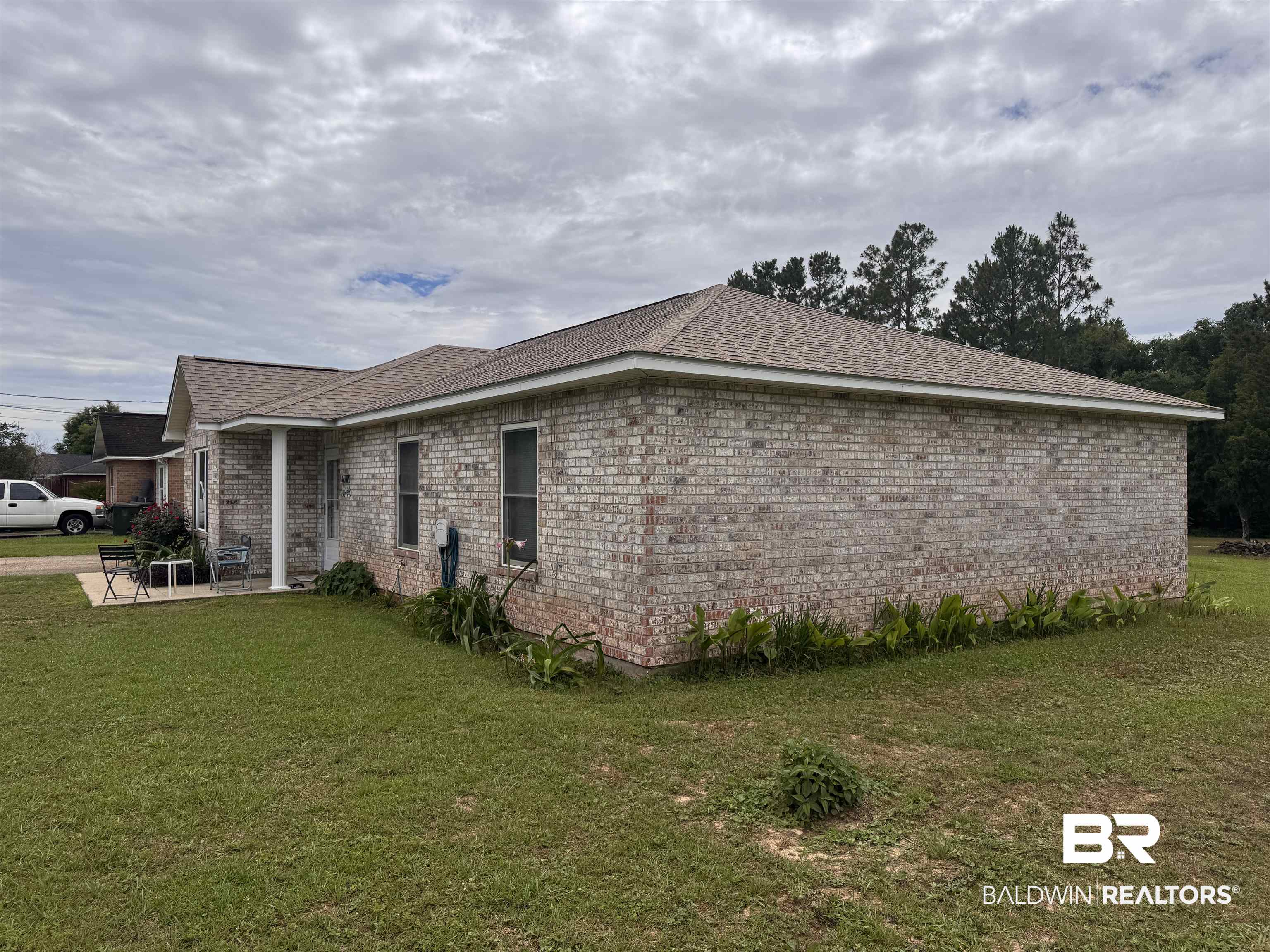 15148 Highland Circle Foley, AL 36535 - Photo 3 of 47 View of home's exterior with a yard, brick siding, and a patio