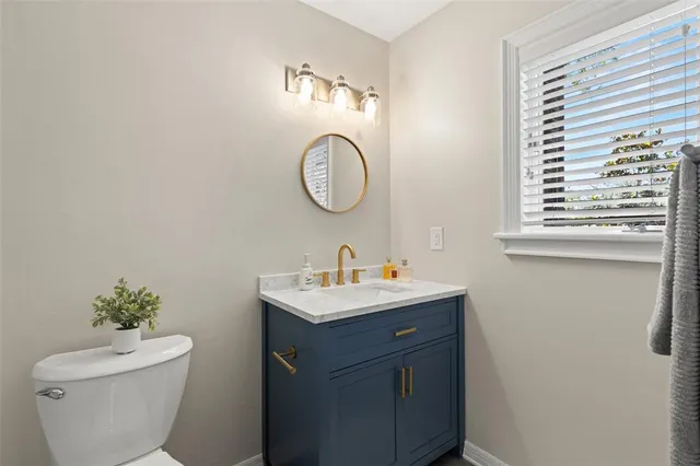 a bathroom with a toilet a sink and a mirror