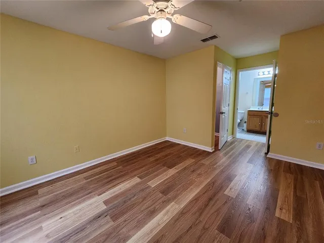 a view of empty room with wooden floor