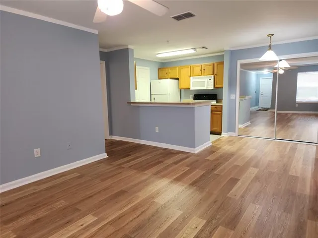 a view of a livingroom with wooden floor and a ceiling fan