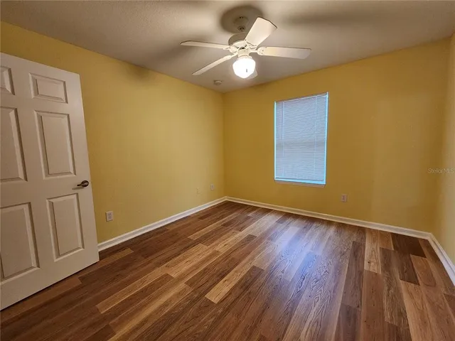 a view of an empty room with wooden floor