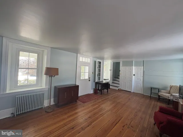 a view of empty room with a window and wooden floor