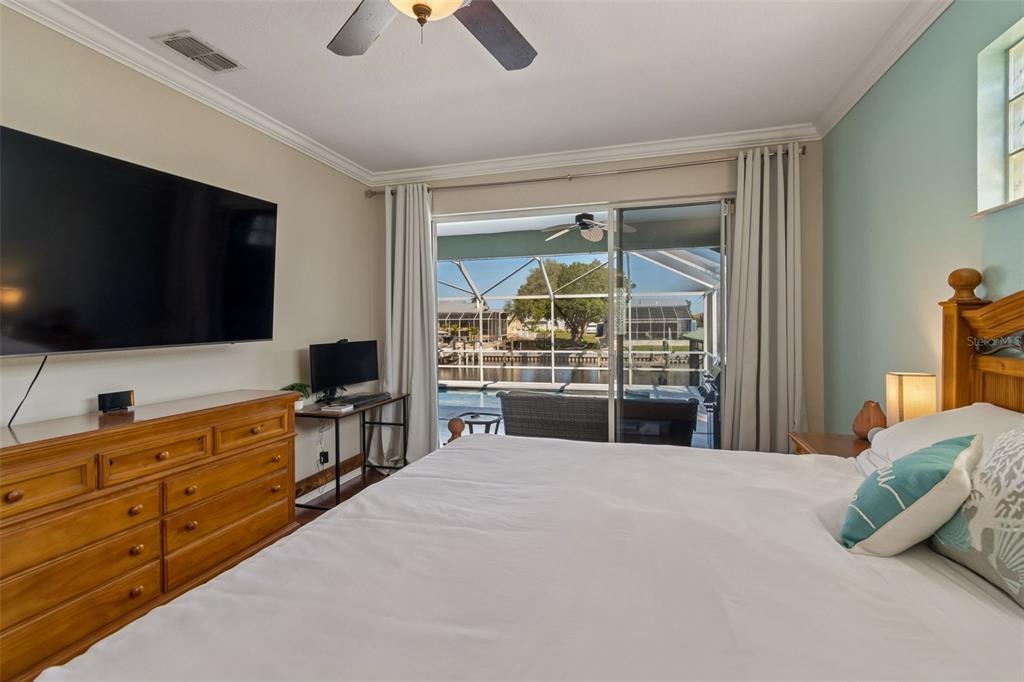 703 Bunker View Drive Apollo Beach, FL 33572 - Photo 20 of 49 a bedroom with a bed and a flat tv screen on dresser