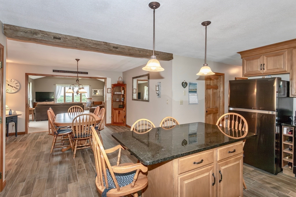 85 Lyman Road Chester, MA 01011 - Photo 8 of 34 a kitchen with stainless steel appliances granite countertop a stove a refrigerator a kitchen island a dining table and chairs