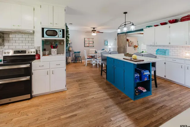 a large kitchen with lots of counter space and wooden floor