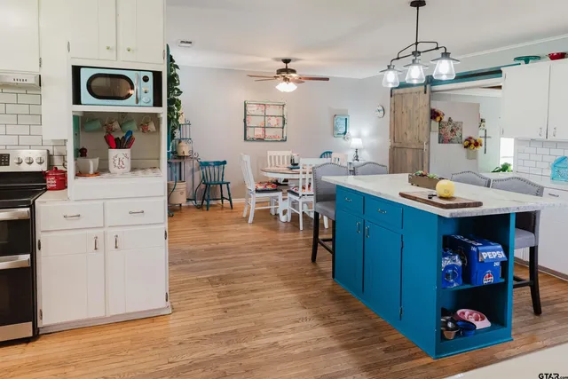 a open kitchen with stainless steel appliances granite countertop a white cabinets and stove top oven