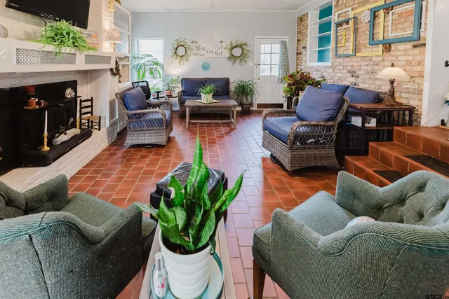 a living room with furniture a fireplace and a potted plant