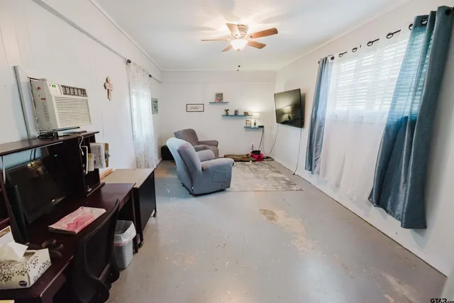 a living room with furniture a flat screen tv and a window