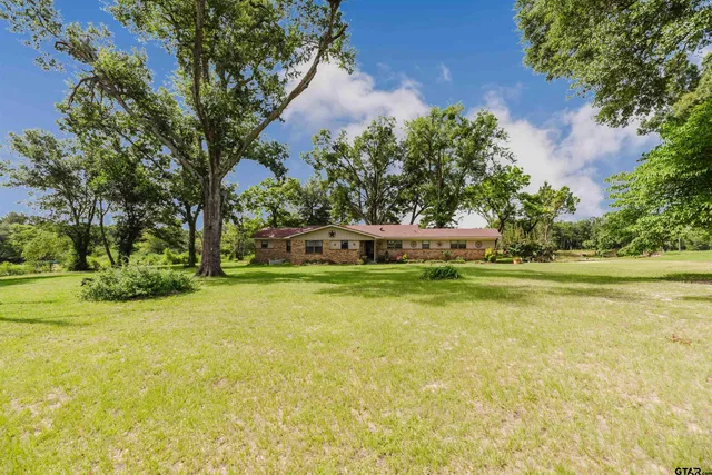 a house view with swimming pool in front of it