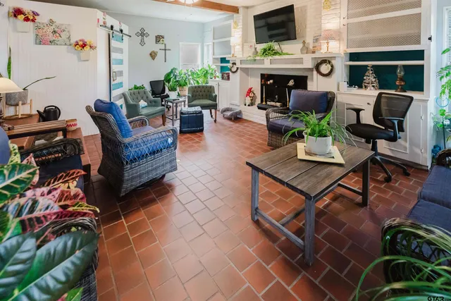a living room with furniture a flat screen tv and a fireplace