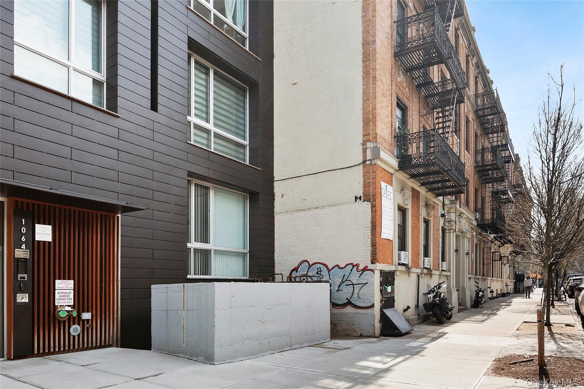 1064 Hancock Street, Unit 101 Brooklyn, NY 11221 - Photo 8 of 9 Modern facade featuring dark horizontal siding and a vertical slatted entry