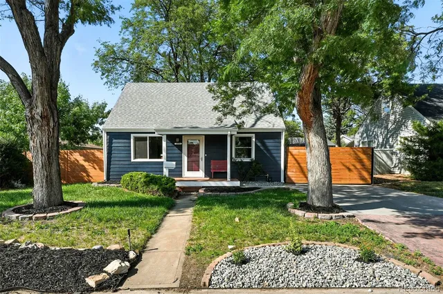 a front view of a house with a yard and trees